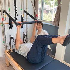 マシンピラティス指導を受けている女性の写真